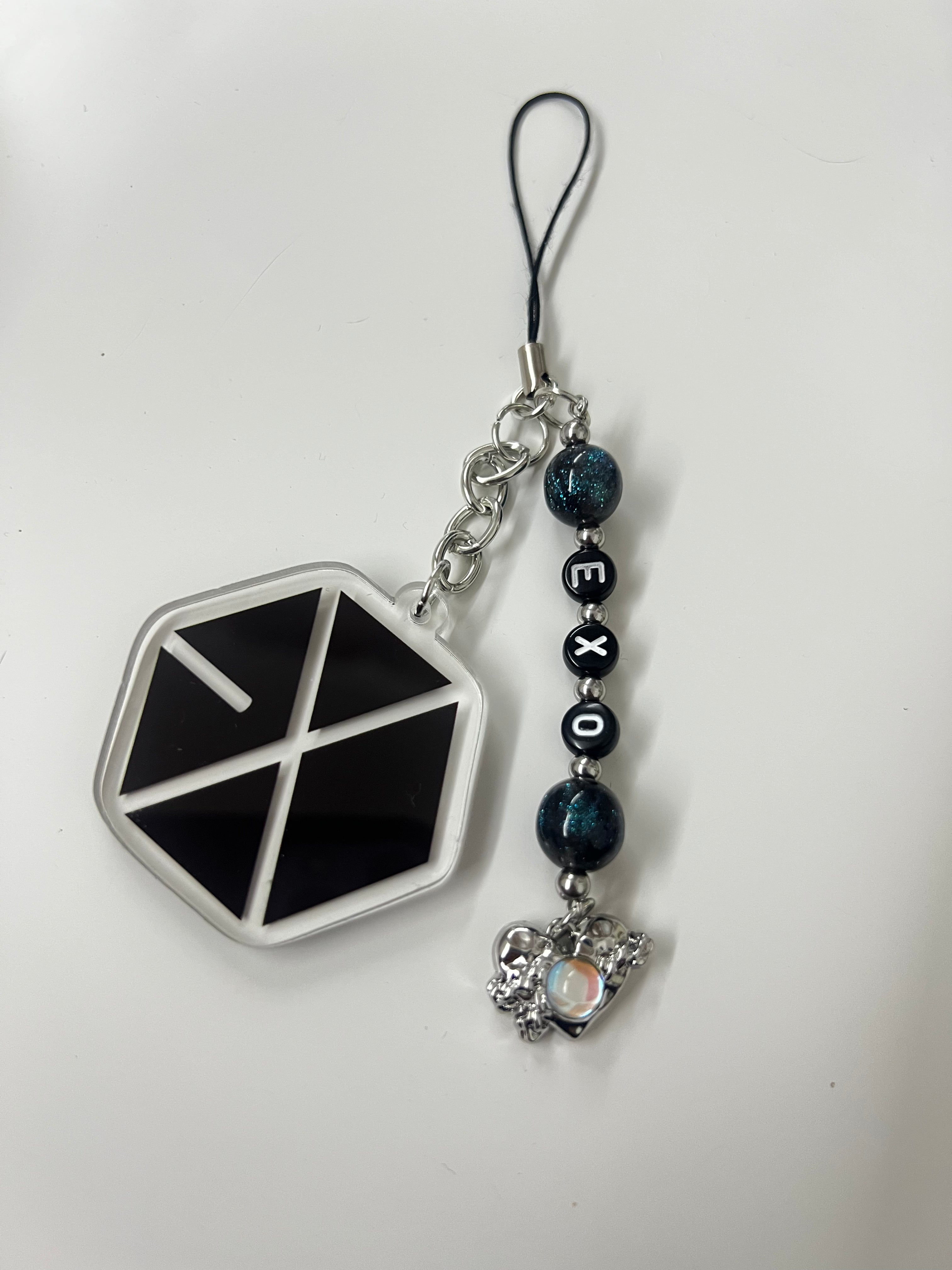 Phone charm with geometric design and EXO logo on a white background